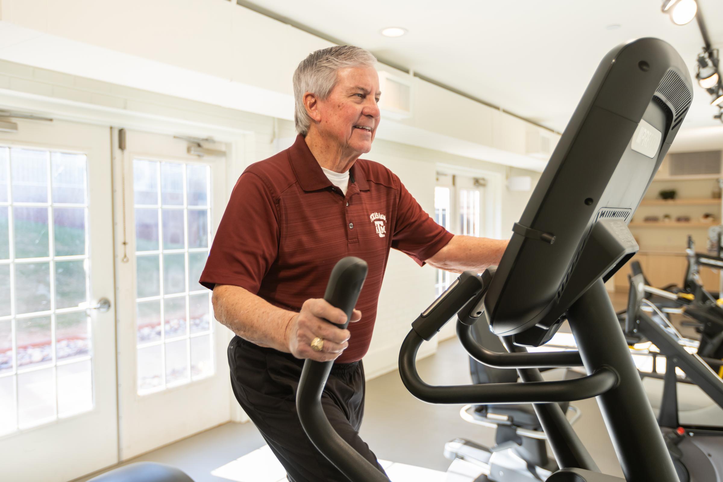 24-FWB-IL-FitnessCenter-Res-015 senior on exercise machine