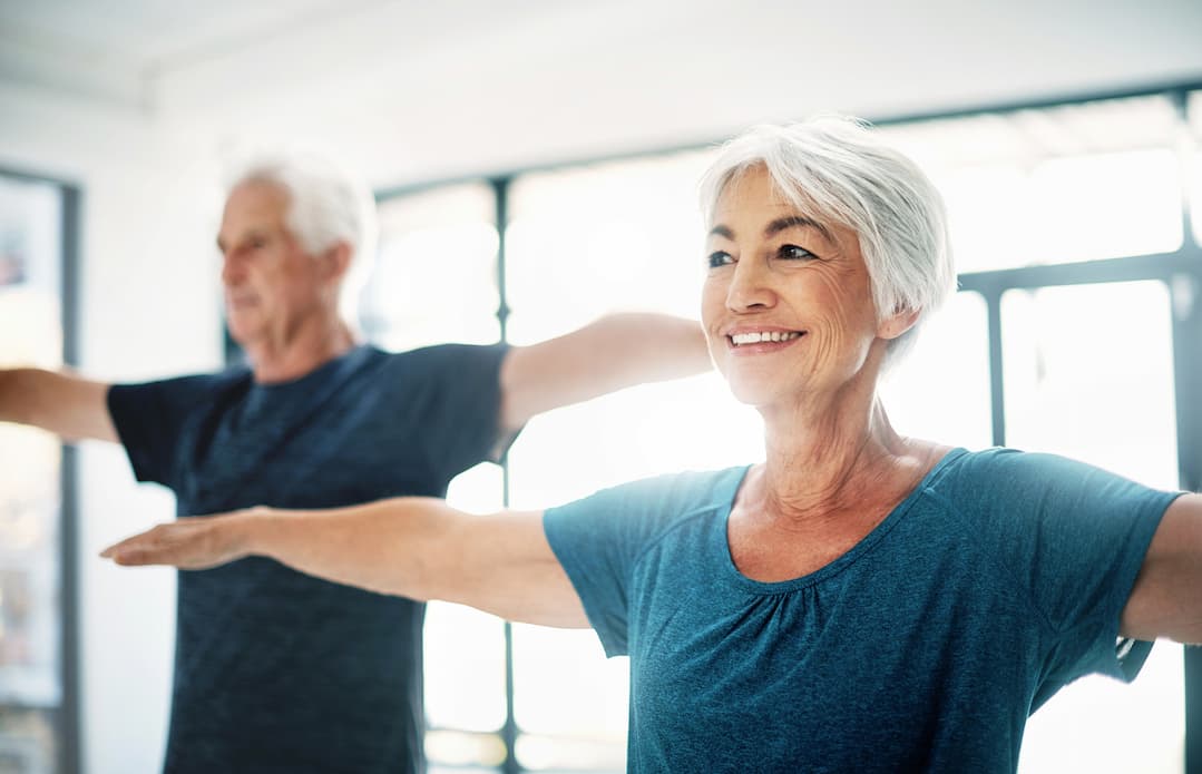 two seniors stretching in exercise class