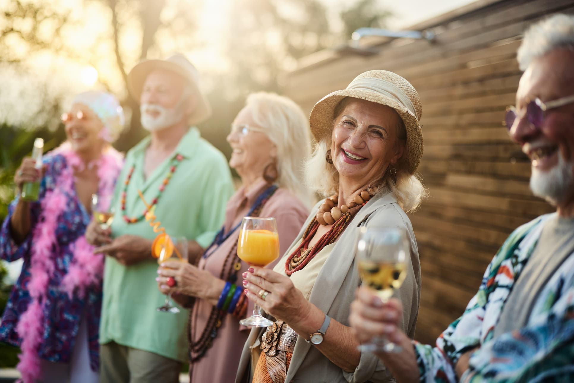 senior friends at fun outdoor event enjoying cocktails