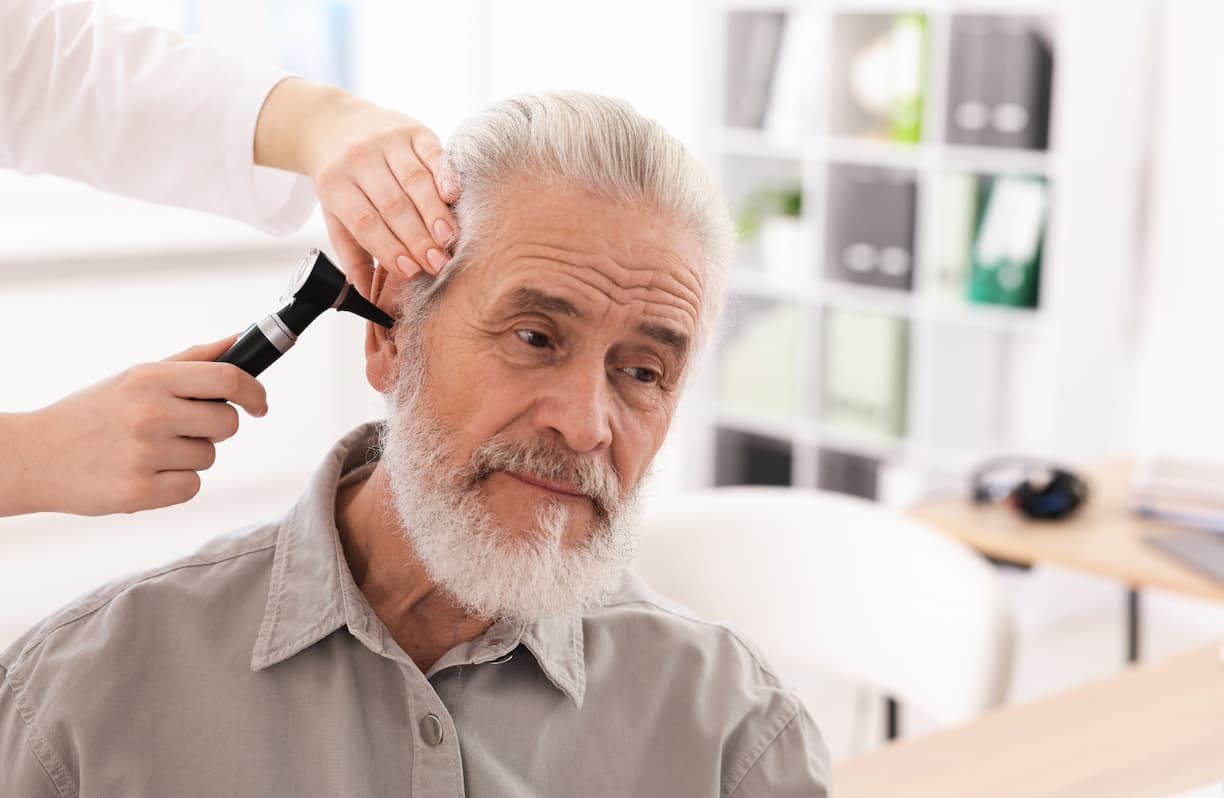 man getting ear checked by doctor