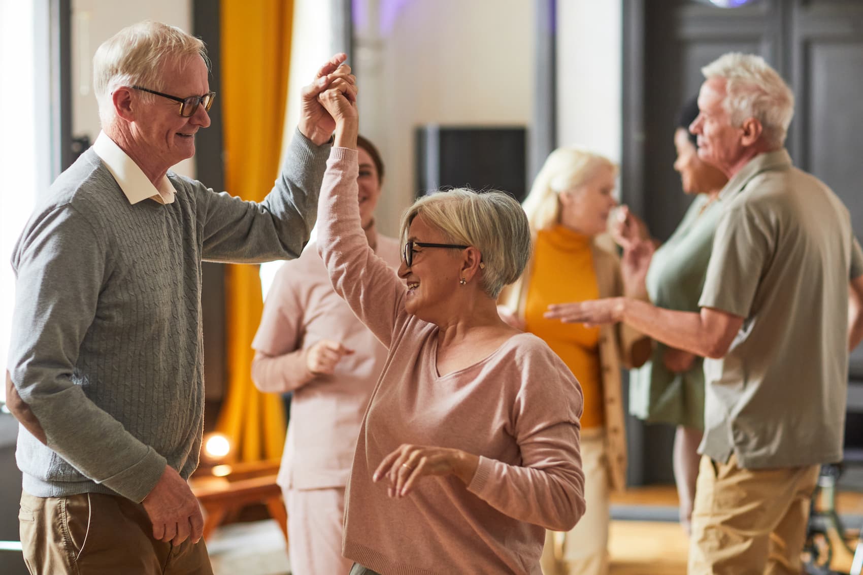 senior couple dancing at a party at a senior living community