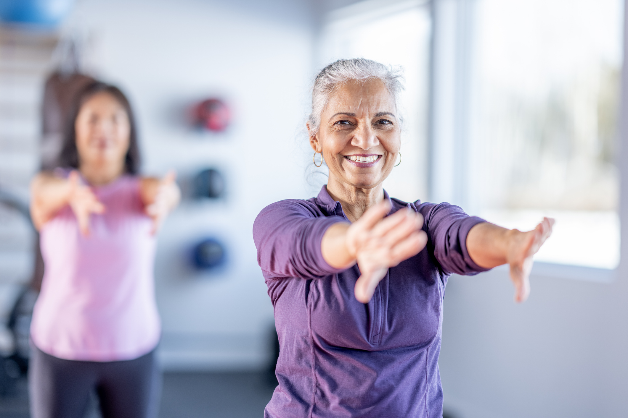 senior women doing yoga in group class