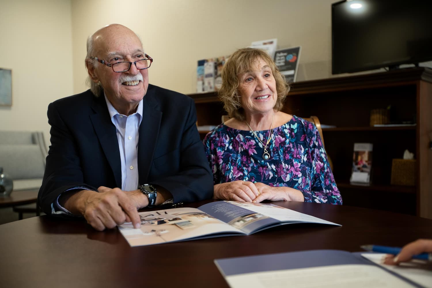 senior-couple-during-meeting-broadway-cityview Senior couple sitting at desk during a meeting listening to professional