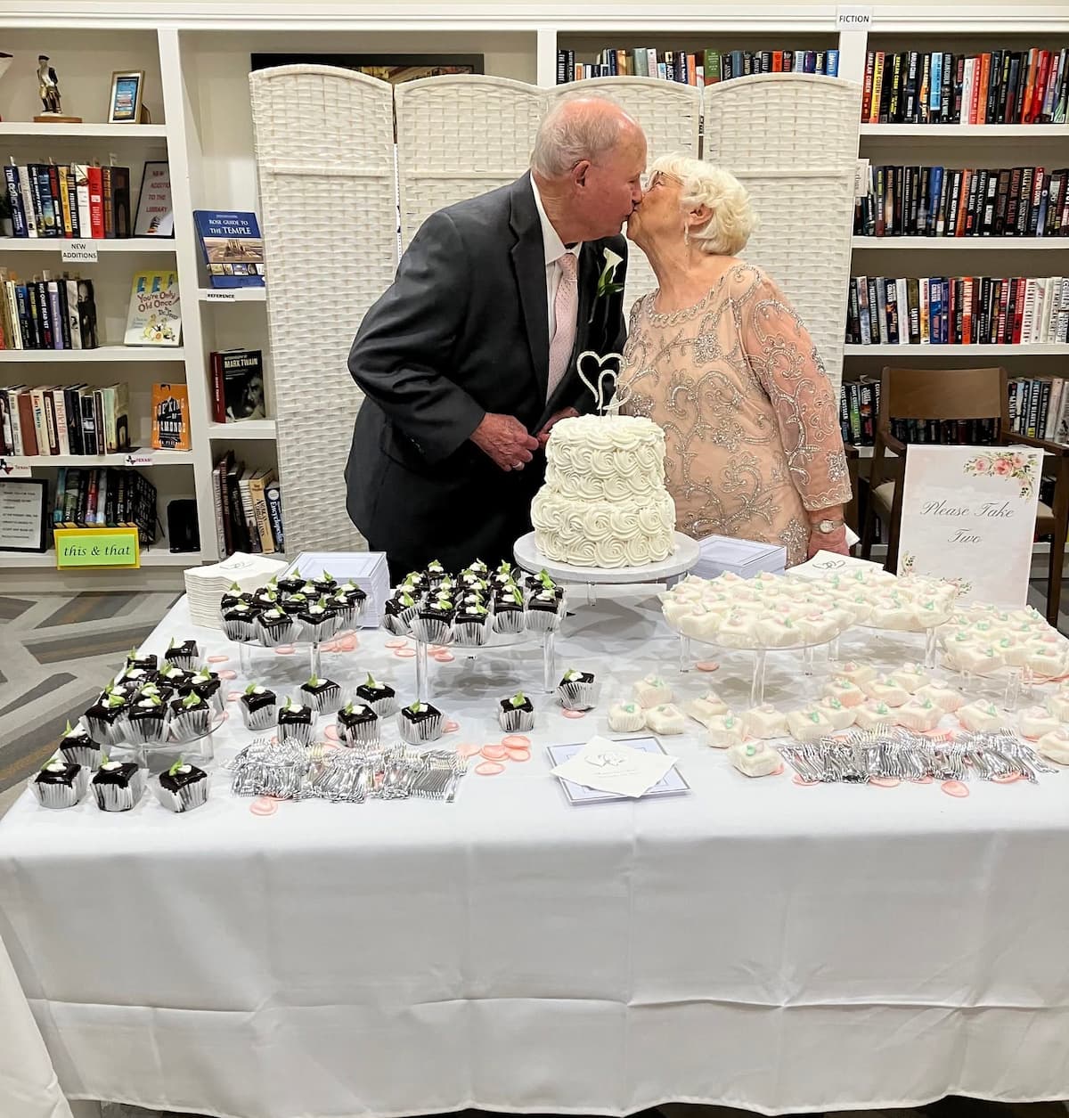 Bill and Sharon Hampton kissing near wedding cake